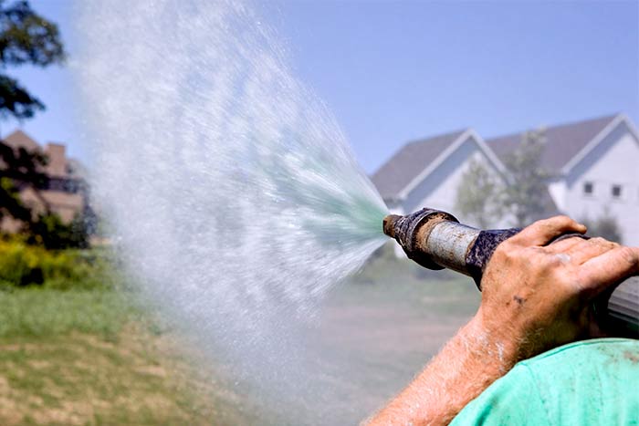 Should You Water Hydroseed Right Away man water plants